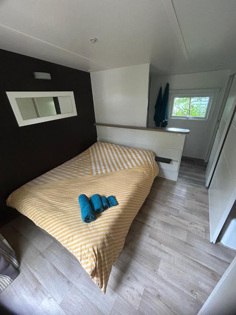 une chambre avec un lit avec deux oreillers bleus dessus dans l'établissement Mobil Home confort 6p, à Cadenet