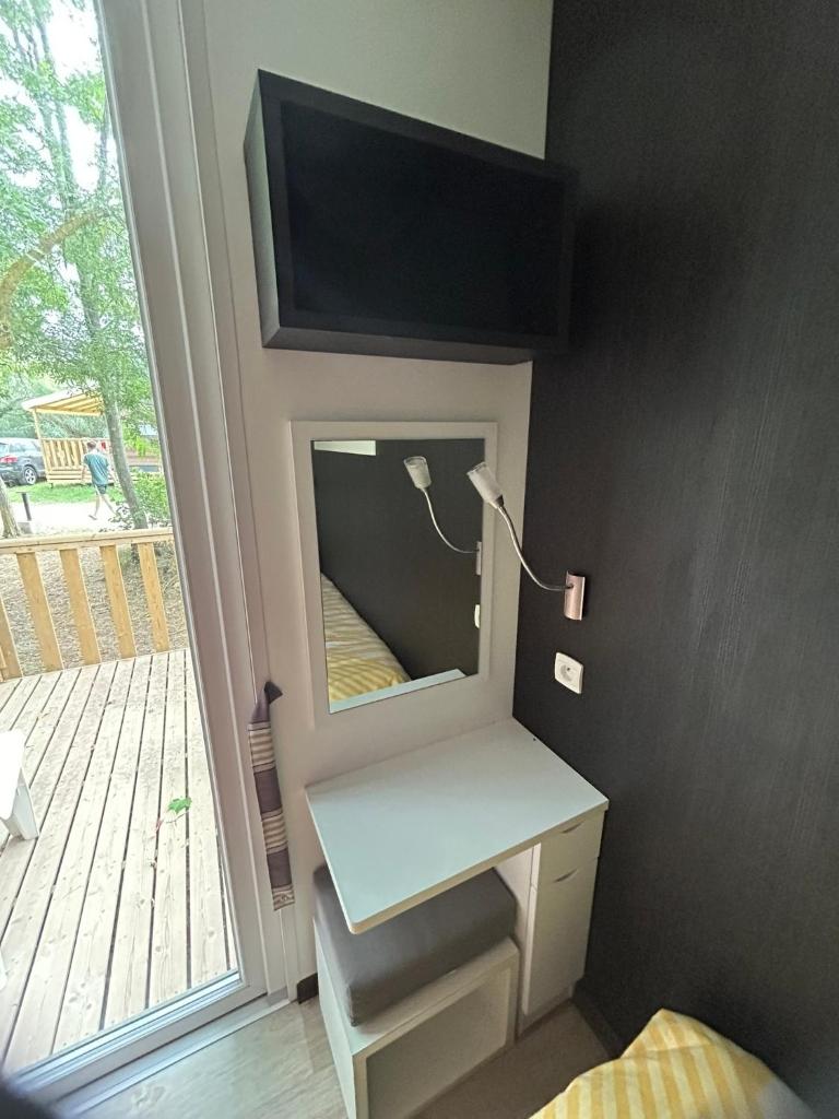 - une chambre avec un miroir, un bureau et une fenêtre dans l'établissement Mobil Home confort 6p, à Cadenet