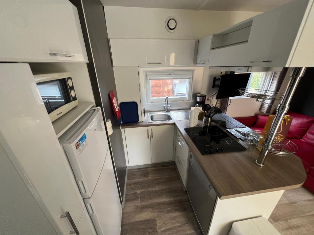 Il comprend une petite cuisine avec un évier et un comptoir. dans l'établissement Mobil Home confort 6p, à Cadenet 1 autre photo