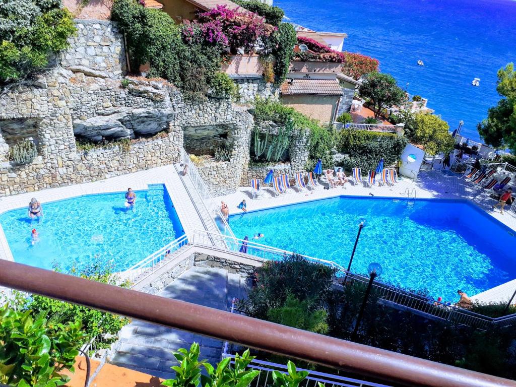 une vue d'une piscine avec des gens dans l'eau dans l'établissement Conca Verde c15-Beach front little villa POOL SPA BEACH, à Marina dʼAndora