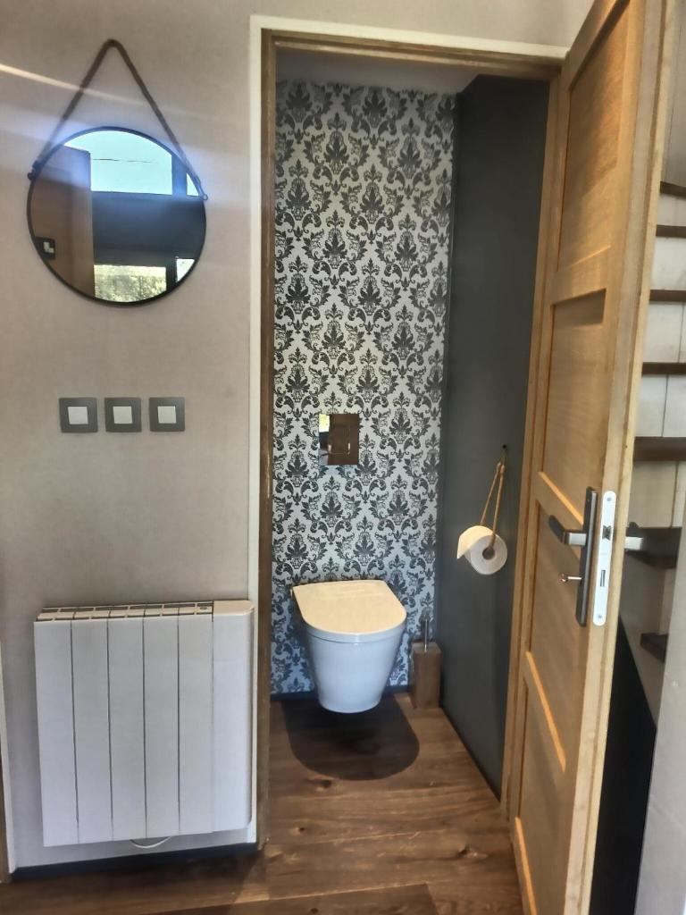 une salle de bain avec toilettes et miroir dans l'établissement Les Kabanes de Kerforn, à Crach