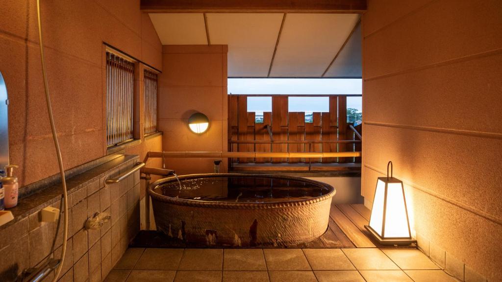 - une salle de bains avec une grande baignoire au milieu d'une pièce dans l'établissement Omoideno Jinde, à Izu