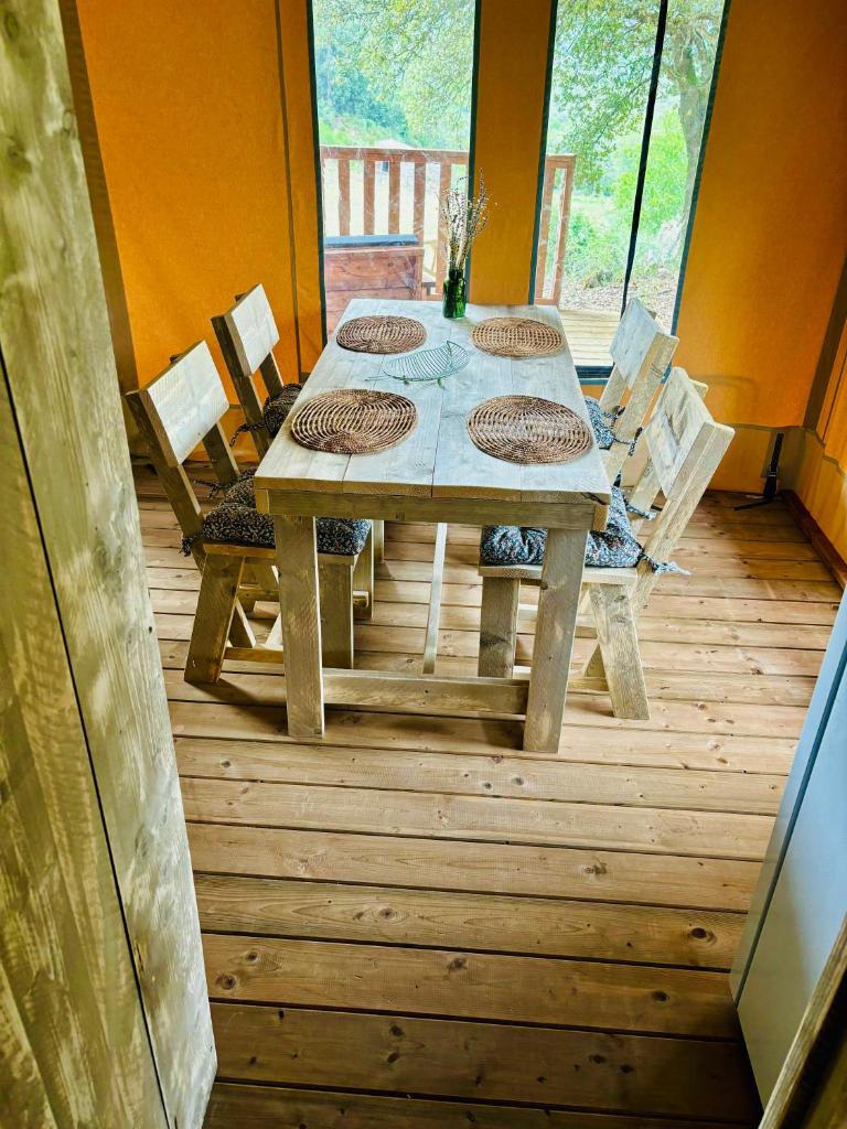 une table et des chaises en bois sur une terrasse en bois dans l'établissement Lodge A NASSA, à Olivese
