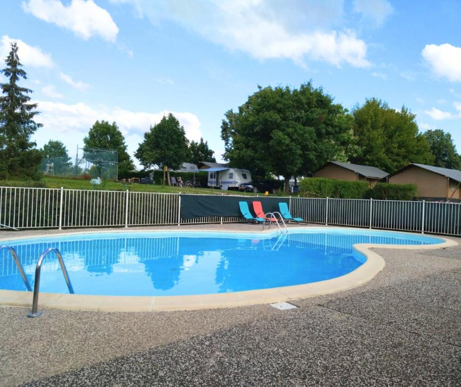 une piscine entourée d'une clôture dans l'établissement Camping du Lac, à Villegusien Le Lac