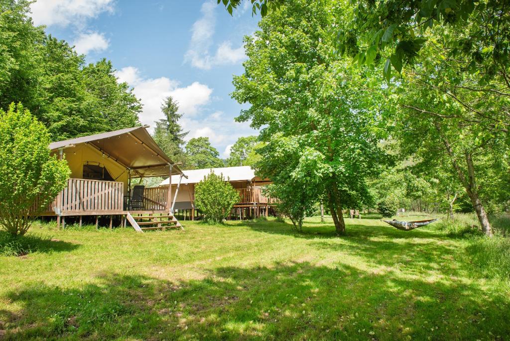 une cabane dans les bois avec une cour dans l'établissement Camping Pittoresque, à Saint-Parthem