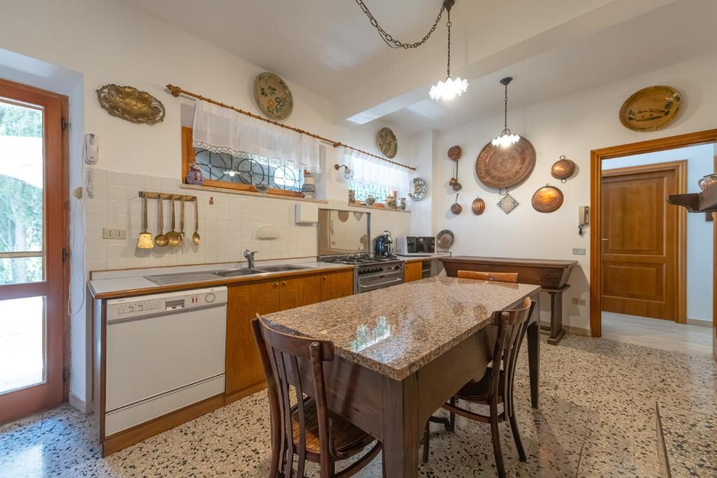 une cuisine avec une table et un comptoir dans l'établissement Villa Stipa with pool by Quokka 360 - Close to Riviera delle Palme, à Offida