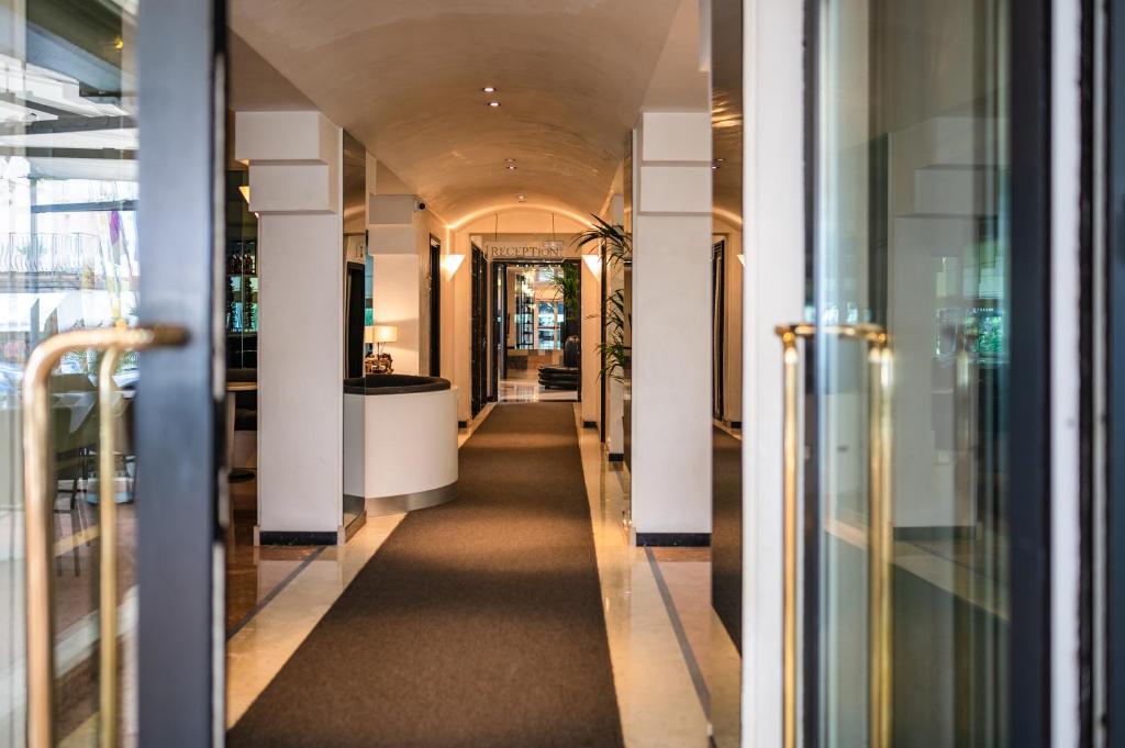 un couloir dans un immeuble de bureaux avec un couloir menant à une porte dans l'établissement Hotel Europa, à Lido di Jesolo