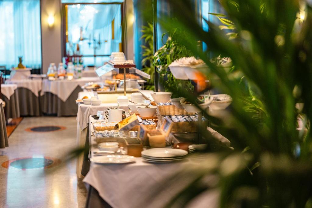 - une grande table avec des assiettes et de la vaisselle dans l'établissement Hotel Europa, à Lido di Jesolo 68 autres photos