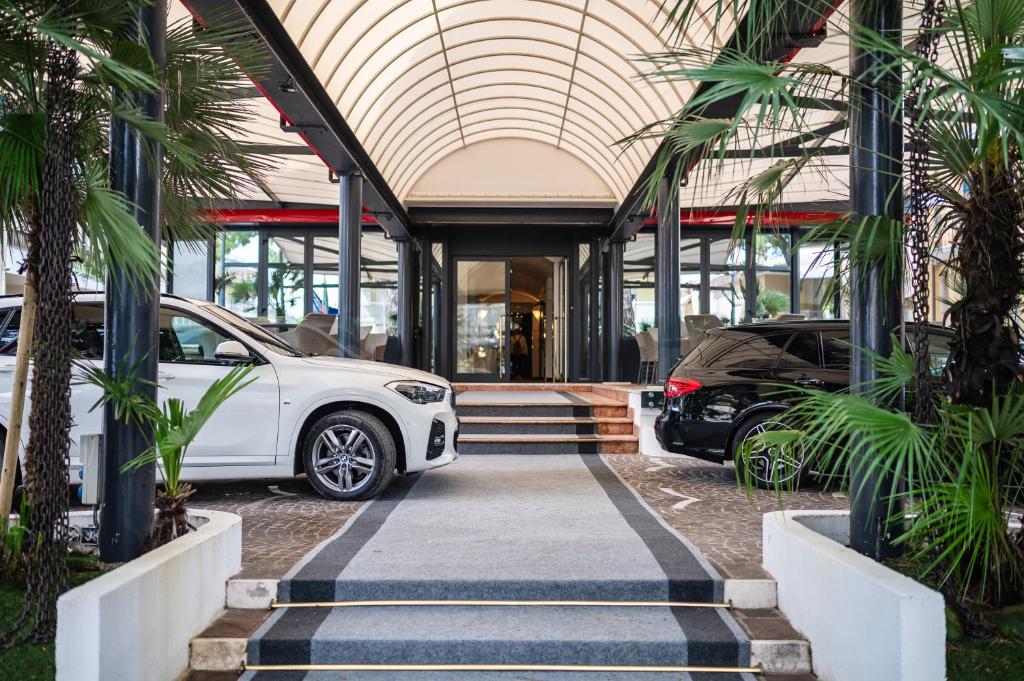 une voiture blanche garée devant un immeuble dans l'établissement Hotel Europa, à Lido di Jesolo