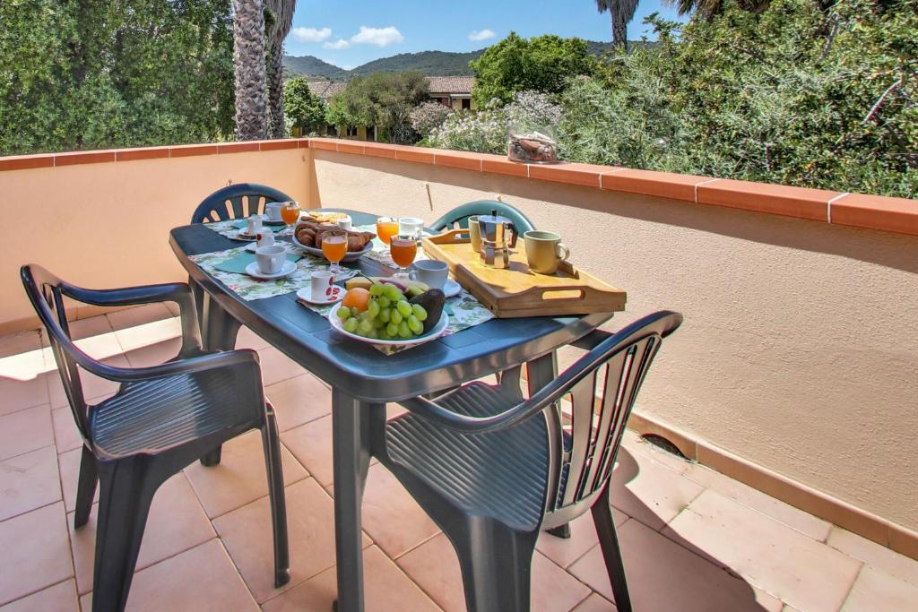 une table avec un bol de fruits sur une terrasse dans l'établissement Residence Oasi Anfiteatro, à Porto Ottiolu