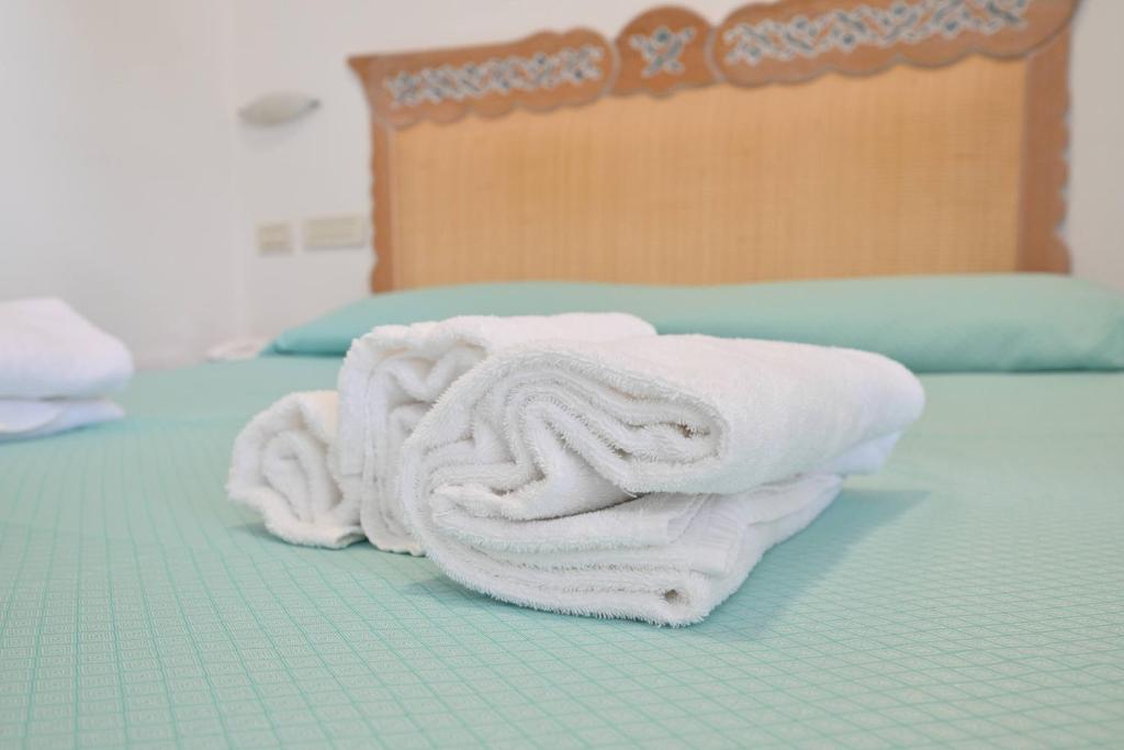 une pile de serviettes posée sur un lit dans l'établissement Av Isola Verde Hotel Thermal Spa, à Ischia
