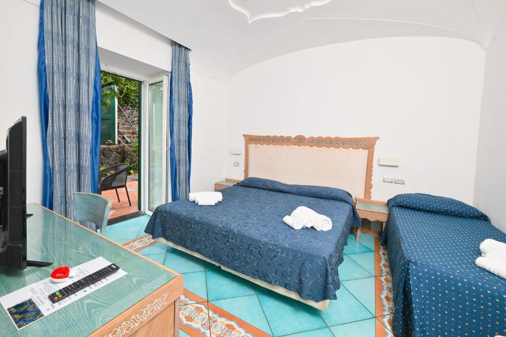 une chambre avec un lit, un bureau et une télévision dans l'établissement Av Isola Verde Hotel Thermal Spa, à Ischia