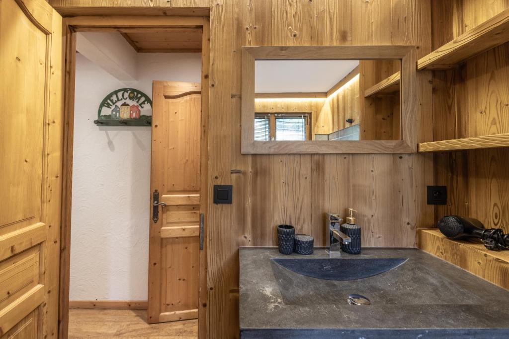 une salle de bain avec un lavabo et un miroir dans l'établissement Le chalet d Anita, à Megève