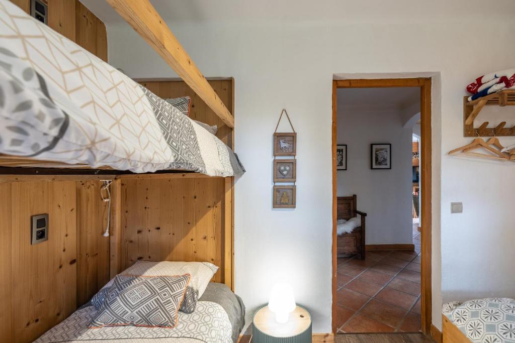Cette chambre dispose de lits superposés, d'un canapé et d'une lampe. dans l'établissement Le chalet d Anita, à Megève