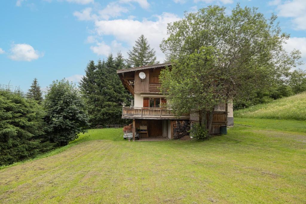 une maison sur une colline avec un arbre dans l'établissement Le chalet d Anita, à Megève