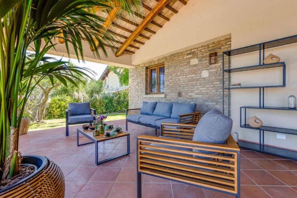 un patio avec un canapé et des chaises bleus dans l'établissement La Dolce Villa, à Rimini