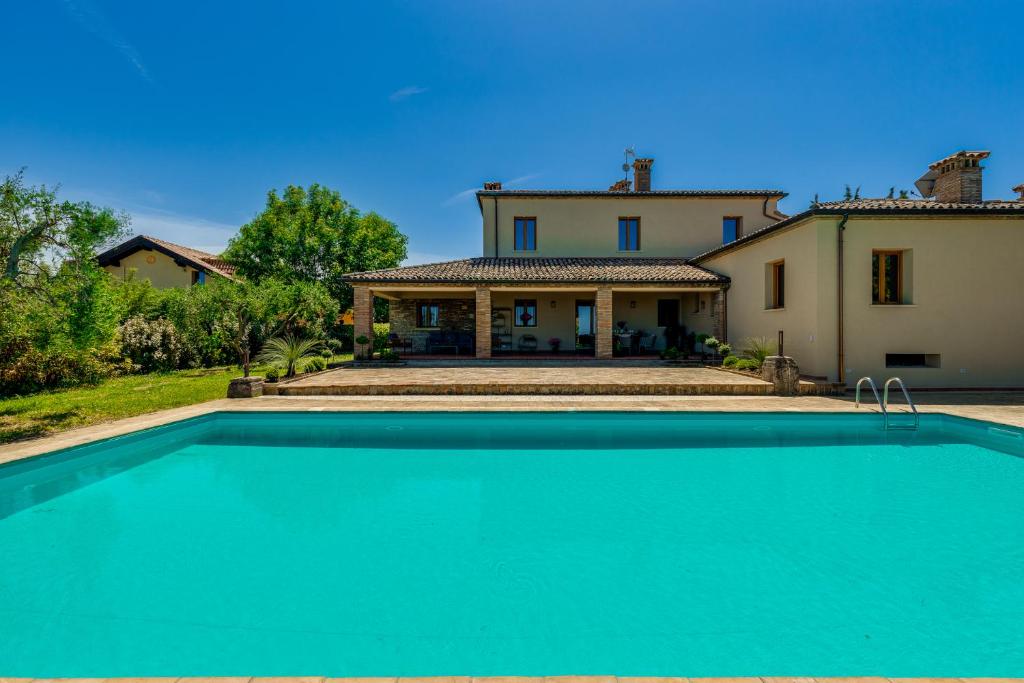 une maison avec une piscine devant une maison dans l'établissement La Dolce Villa, à Rimini