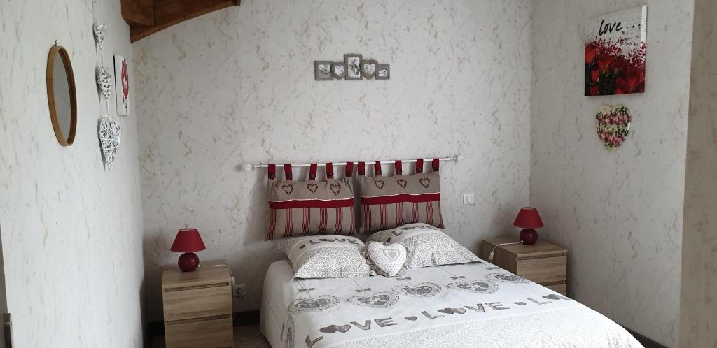 - une chambre avec un lit, 2 tables de chevet et 2 lampes dans l'établissement Gîtes Am Go, à Saint-Crépin-et-Carlucet