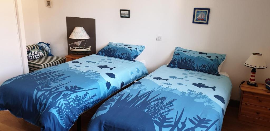 une chambre avec deux lits avec des poissons et des plantes dans l'établissement Gîtes Am Go, à Saint-Crépin-et-Carlucet