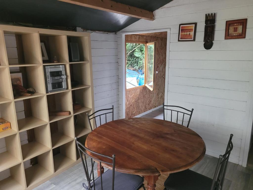 - une salle à manger avec une table, des chaises et des étagères dans l'établissement Yourte et Chalet avec piscine, à Nivillac
