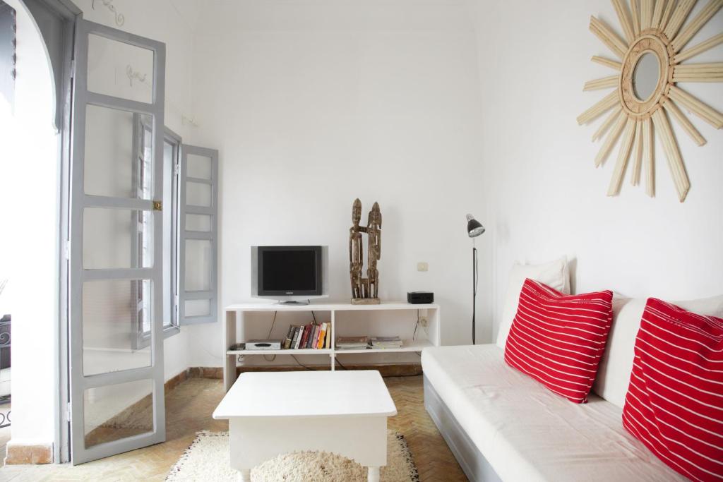 - un salon avec un canapé blanc et des oreillers rouges dans l'établissement Riad Dar Wildeve, à Marrakech