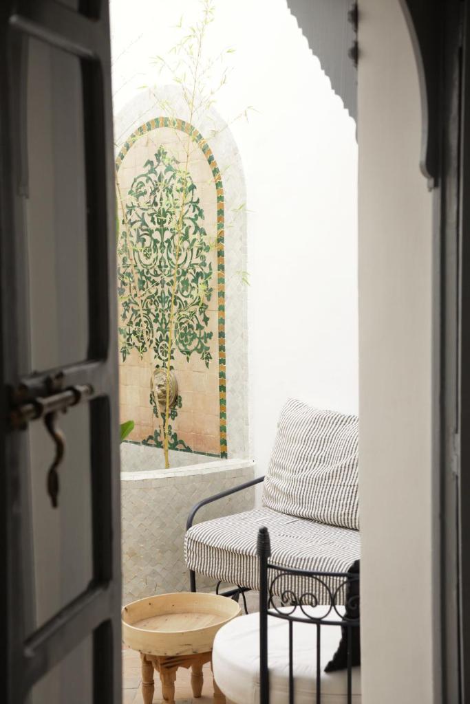 une porte menant à une chambre avec un canapé et une table dans l'établissement Riad Dar Wildeve, à Marrakech