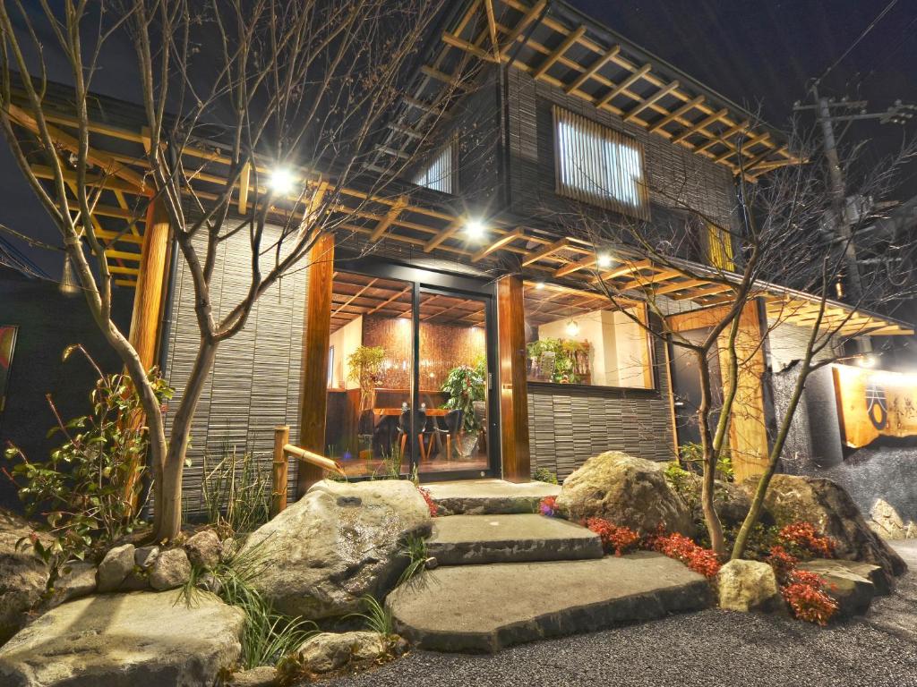 une maison avec un chemin en pierre devant elle dans l'établissement Totonoinoyado Shuntouan, à Beppu