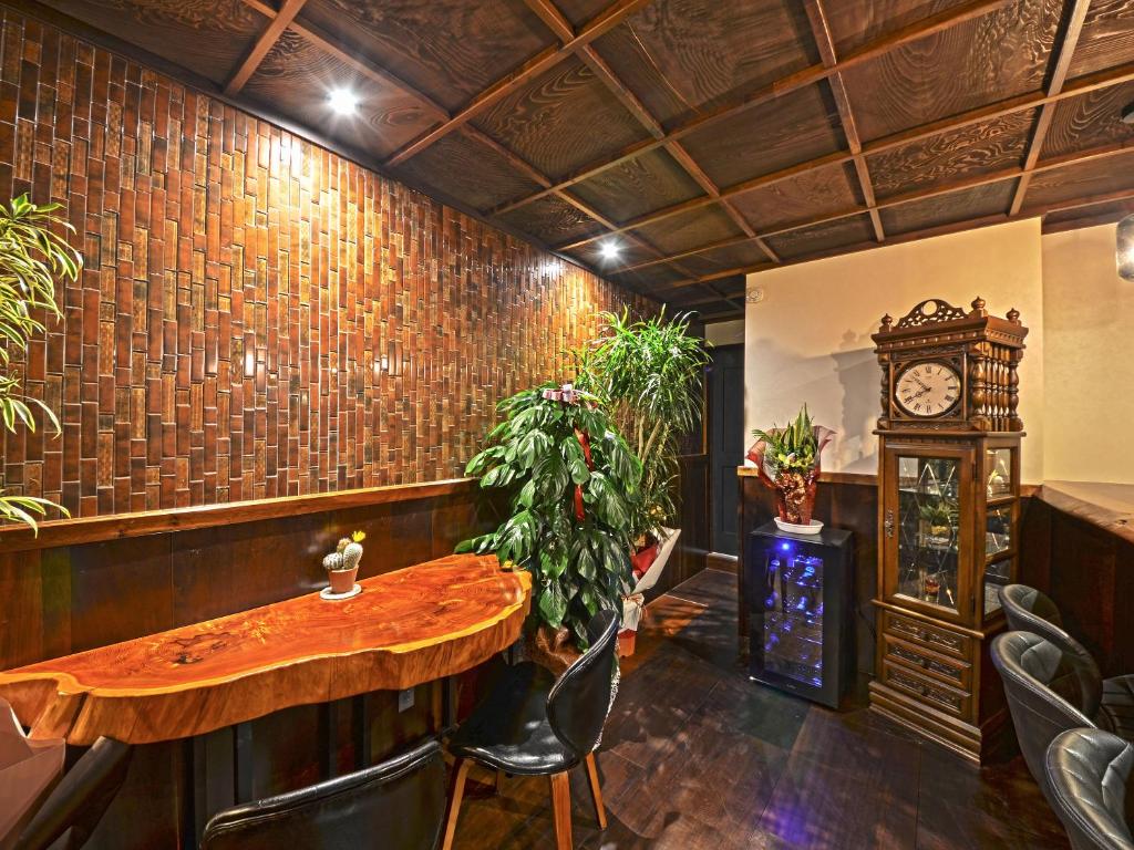 un bar avec une table en bois et une horloge grand-père dans l'établissement Totonoinoyado Shuntouan, à Beppu