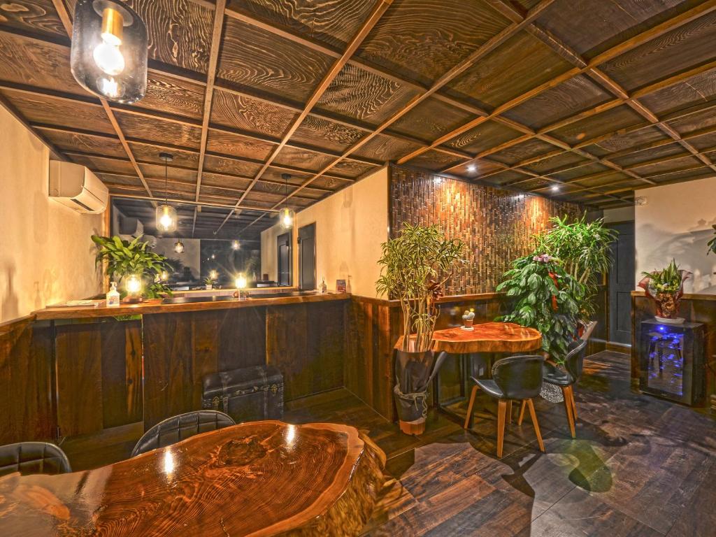 un restaurant avec des tables et un bar avec des plantes dans l'établissement Totonoinoyado Shuntouan, à Beppu
