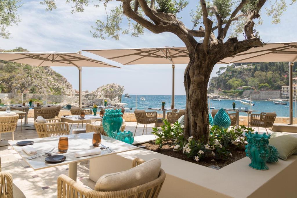 un restaurant avec vue sur l'eau dans l'établissement Mazzarò Sea Palace - The Leading Hotels of the World, à Taormine