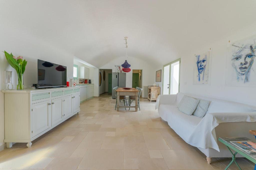 un salon avec un canapé blanc et une cuisine dans l'établissement Villa Eva, villa privata con piscina a sfioro, à Ostuni
