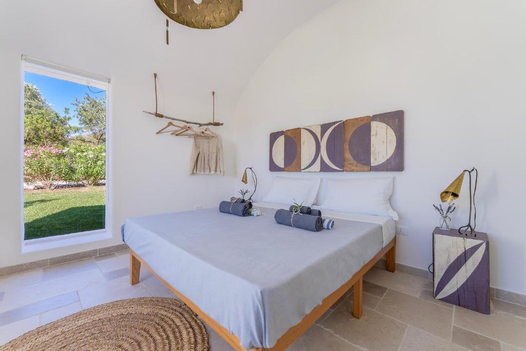 une chambre avec un lit et une grande fenêtre dans l'établissement Villa Eva, villa privata con piscina a sfioro, à Ostuni