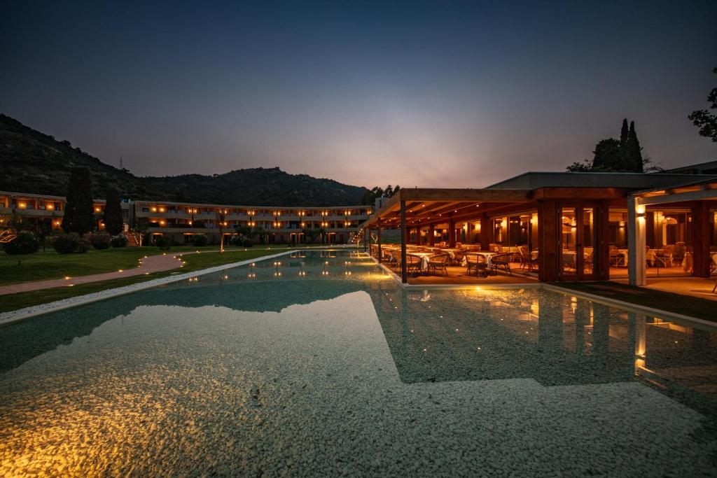 une grande piscine devant un immeuble la nuit dans l'établissement Is Molas Resort, à Pula