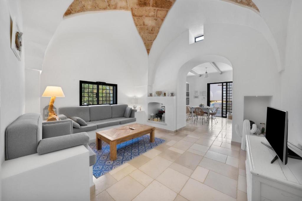 un salon avec un canapé et une table dans l'établissement CA' DEL FICO D'INDIA - Antico Casale di charme, à Casarano