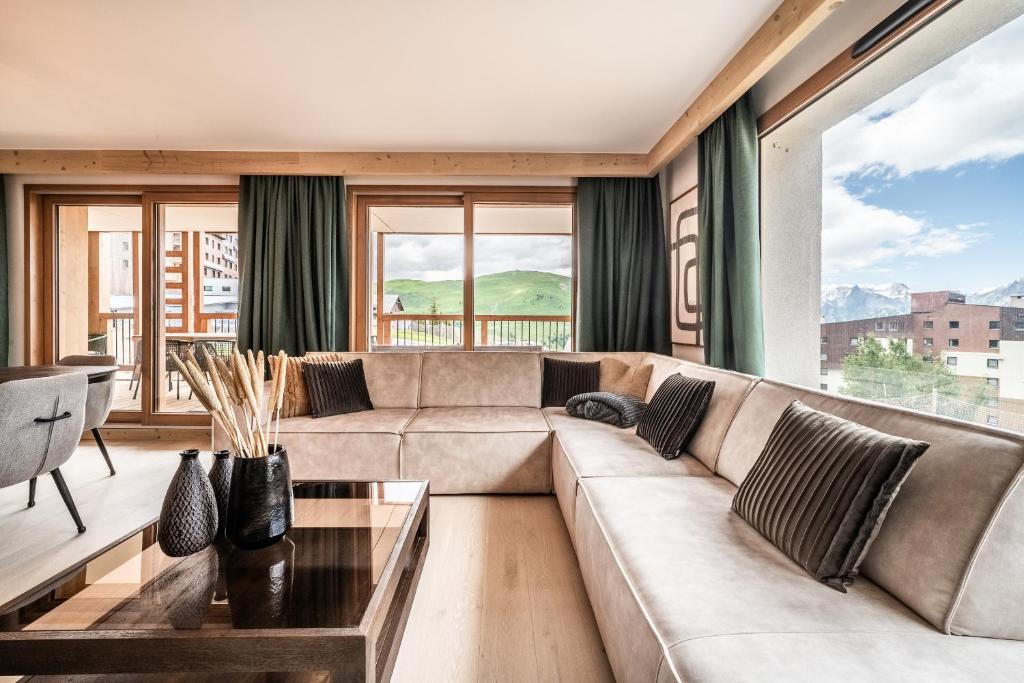 un salon avec un canapé et une table dans l'établissement Apartment Tineo Alpe D'Huez - by EMERALD STAY, à L'Alpe-d'Huez 33 autres photos