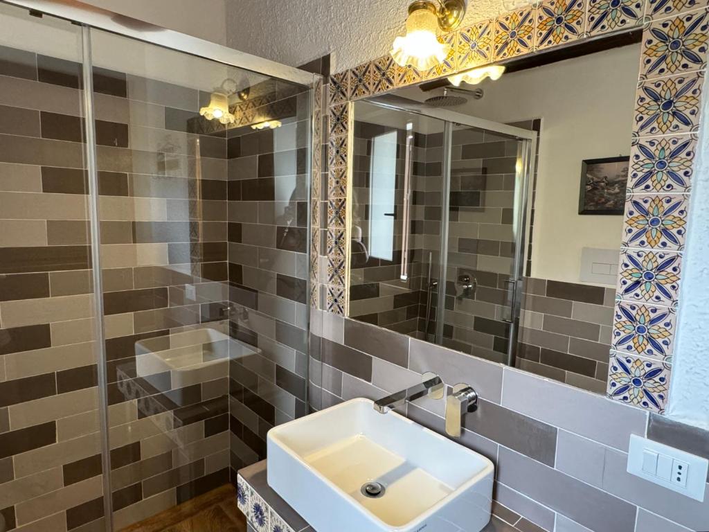 une salle de bain avec un lavabo et un miroir dans l'établissement Casale Nocellara, à Scopello