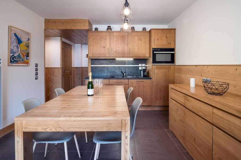 - une cuisine avec une table à manger en bois et des chaises dans l'établissement ALPA appartements - Champagny-en-Vanoise, à Champagny-en-Vanoise