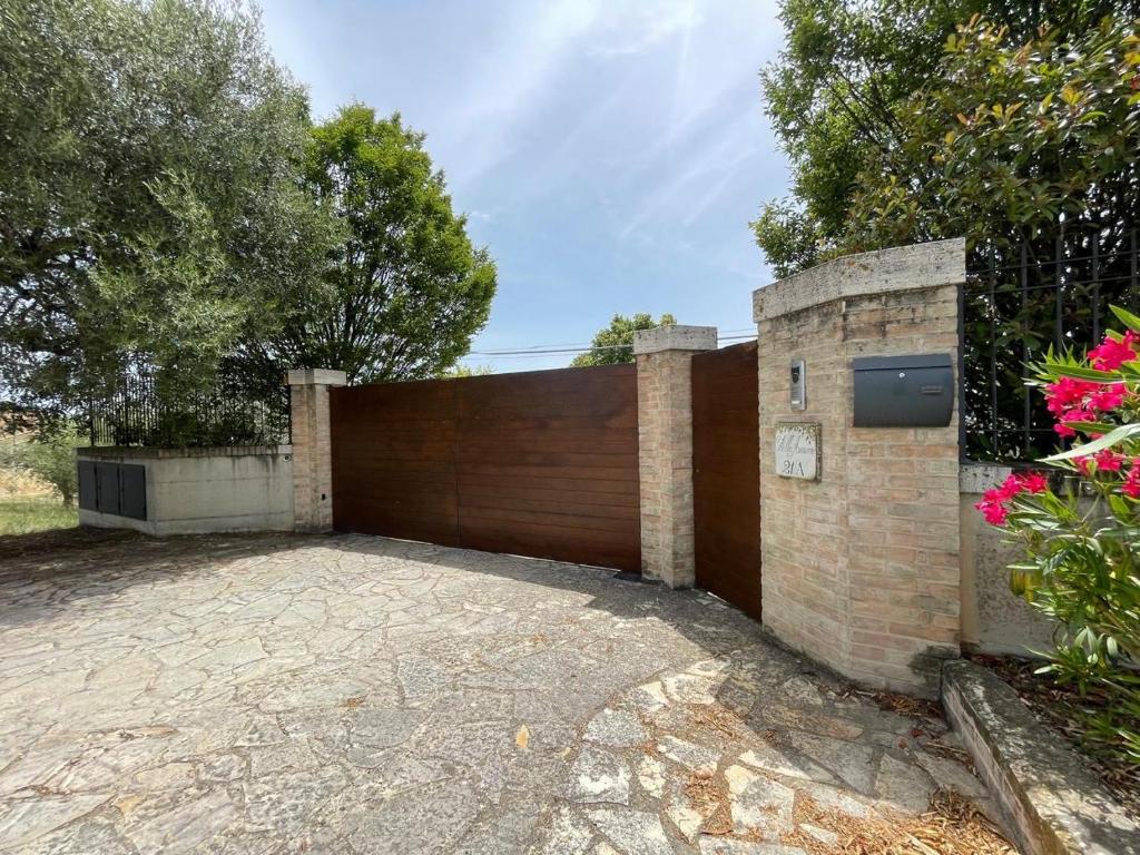 une clôture en bois avec un portail dans une allée dans l'établissement Villa Azzurra, à Porto SantʼElpidio