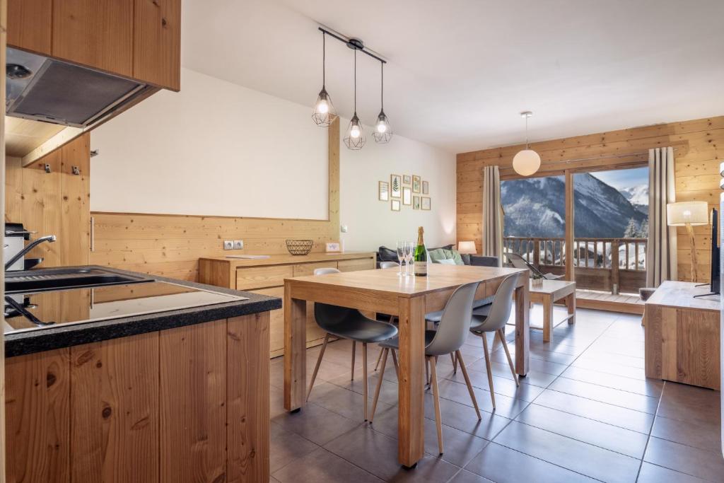 une cuisine avec une table et des chaises ainsi qu'une salle à manger dans l'établissement ALPA appartements - Champagny-en-Vanoise, à Champagny-en-Vanoise