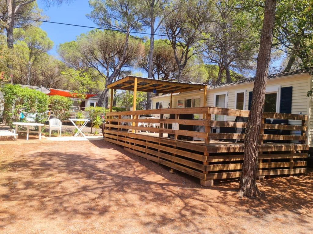 une clôture en bois devant une maison dans l'établissement La Baume La Palmeraie Camping Resort, à Fréjus