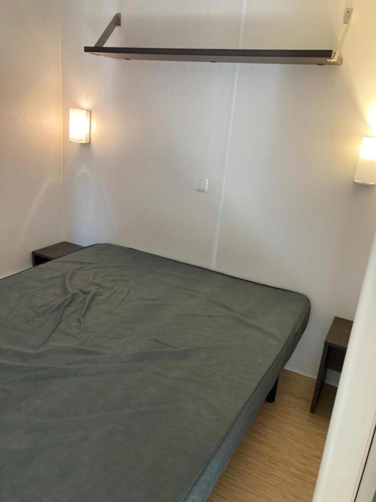 Ce lit se trouve dans un dortoir doté de 2 lumières sur le mur. dans l'établissement camping paisible Marvilla park, à Agde 1 autre photo