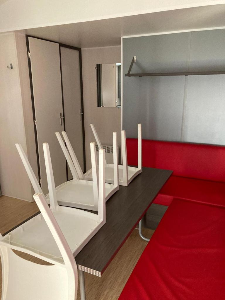une salle à manger avec des chaises blanches et une table dans l'établissement camping paisible Marvilla park, à Agde