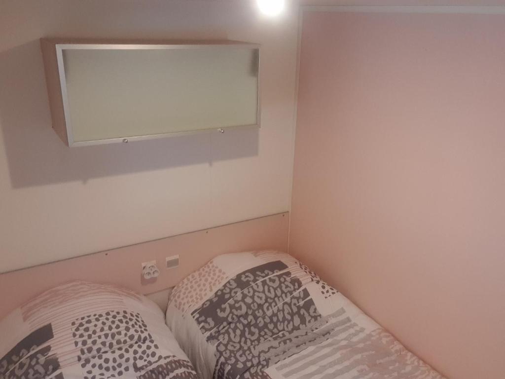 une petite chambre avec un lit et un miroir dans l'établissement Camping les Cigales - Tikayan, au Muy 18 autres photos