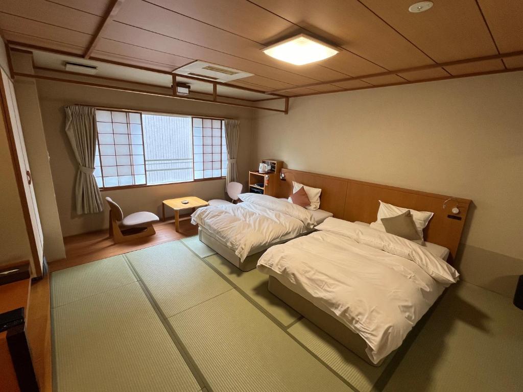 une chambre avec un lit, un bureau et une fenêtre dans l'établissement Takinoya Bekkan Tamanoyu, à Noboribetsu
