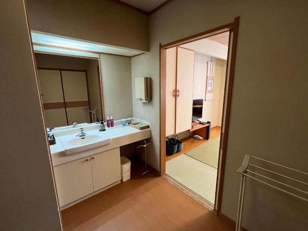 une salle de bain avec un lavabo et un miroir dans l'établissement Takinoya Bekkan Tamanoyu, à Noboribetsu