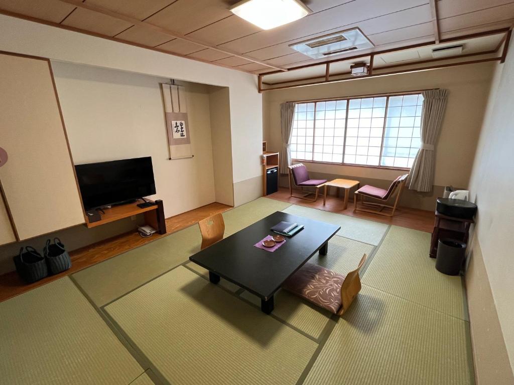 d'un salon avec une table. dans l'établissement Takinoya Bekkan Tamanoyu, à Noboribetsu