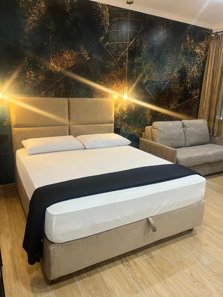 une chambre avec un grand lit et un canapé dans l'établissement Residenza Cristforo Colombo, à Crotone