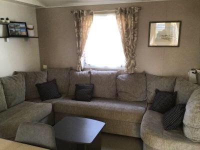 un salon avec un canapé et une fenêtre dans l'établissement Mobilhome au bord de mer, à Piriac-sur-Mer