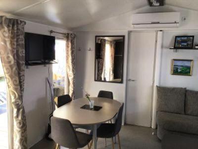 un salon avec une table et un canapé dans l'établissement Mobilhome au bord de mer, à Piriac-sur-Mer