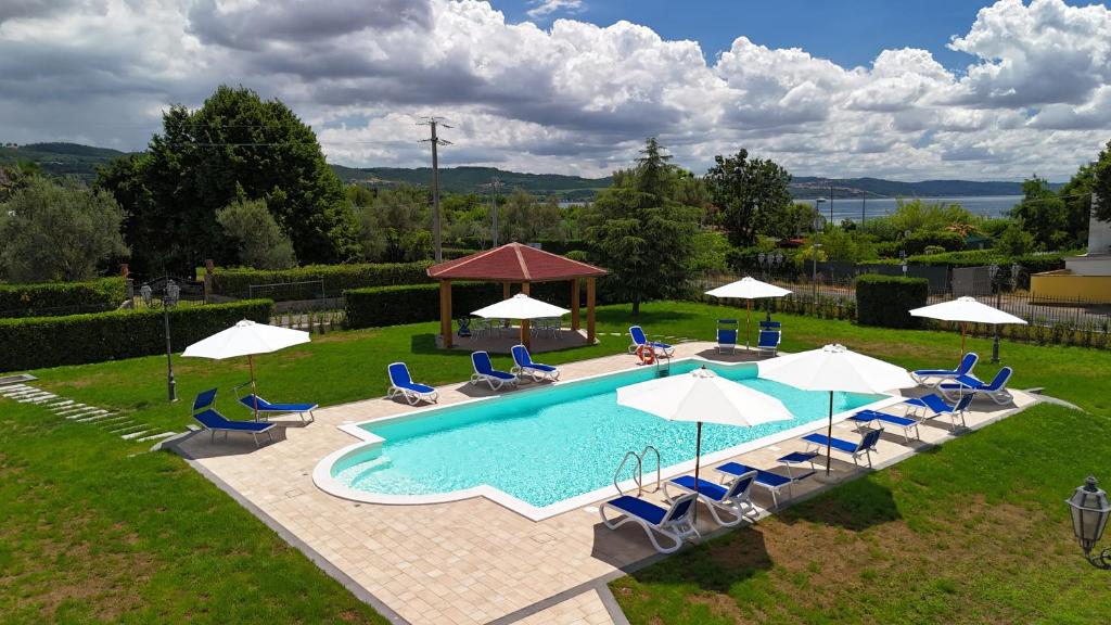 une vue aérienne d'une piscine avec chaises et parasols dans l'établissement Hotel Lido - Beach and Palace, à Bolsena
